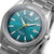Montre homme gros plan : cadran bleu sarcelle, aiguille des secondes jaune, titane argenté