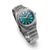 Montre homme 3/4 de profil : cadran bleu sarcelle, bracelet en titane argenté, profil de boîtier distinctif