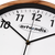 Wanduhr-Zifferblatt mit artvendis Logo, schwarzen Zeigern und Holzrahmen