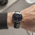 Montre-bracelet au poignet avec bracelet en cuir noir et cadran bleu foncé