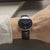 Montre bracelet au poignet avec bracelet en cuir noir et cadran sombre