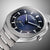 Nahansicht des Zifferblatts der Herrenarmbanduhr mit blauem Muster, Chrono-Optik und Indexen.