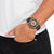 Montre bracelet pour homme au poignet avec bracelet noir et cadran vert clair