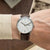 Montre pour homme au poignet : bracelet en cuir marron, cadran blanc avec affichage de la date