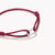 Bracelet textile en ruban rouge avec fermoir argenté et double nœud final
