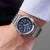 Herrenarmbanduhr am Handgelenk mit blauem Zifferblatt und Edelstahlband