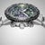 Détail de la montre pour homme : lunette cannelée, cadran vert et sous-cadrans chronographes