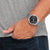 Herrenuhr mit schwarzem Zifferblatt am Handgelenk, silbernes Metallarmband