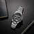 Montre bracelet pour homme, vue de face, avec bracelet en acier inoxydable et cadran noir, sous-cadrans chronographes