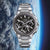 Montre pour homme avec bracelet en métal argenté et cadran noir, sous-cadrans ronds