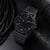 Bracelet de montre pour homme, gros plan cadran noir avec index lumineux verts et aiguilles jaunes