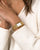 Nahaufnahme Damen-Armbanduhr: goldfarbenes Metallarmband und rechteckiges Zifferblatt mit römischen Ziffern