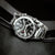 Bracelet de montre pour homme en détail : bracelet en acier inoxydable et cadran noir avec aiguilles.