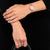 Citizen Damenuhr Roségold am Handgelenk mit Metallgliederarmband und hellem Zifferblatt.