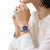 Montre pour femme au poignet avec cadran rond bleu et bracelet en acier inoxydable
