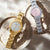 Goldfarbene Damenarmbanduhr mit weißem Zifferblatt und goldfarbenem Edelstahlband