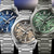 Mehrere Herrenarmbanduhren nebeneinander, silberne Edelstahlarmbänder und grüne Zifferblätter