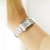 Damenarmbanduhr am Handgelenk mit silbernem Metallarmband und Perlmutt-Zifferblatt