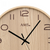 Horloge murale en bois avec cadran en bois clair, aiguilles noires et chiffres imprimés