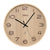 Horloge murale en bois avec cadran beige, aiguilles des heures et des minutes noires, logo AMS