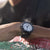 Montre de plongée Luminox au poignet avec bracelet noir et cadran blanc, gouttes d'eau