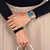 Montre pour femme avec cadran bleu au poignet, bracelet en métal argenté