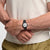 Swatch-Armbanduhr in Nahaufnahme am Handgelenk: schwarzes Band, weißes Zifferblatt