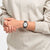 Swatch-Uhr am Handgelenk: schwarzes Silikonarmband, weißes Zifferblatt, Datum sichtbar