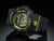 Montre numérique G-Shock, grand écran, noire avec cadre vert lumineux.