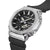 Montre pour homme avec bracelet en caoutchouc noir et boîtier argenté ; poussoirs latéraux visibles.