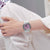 Casio G-Shock GM-S2110 am Handgelenk: lila Zifferblatt, silbernes Gehäuse, weißes Armband