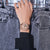 An Hand getragene Damen-G‑Shock-Armbanduhr mit roségoldfarbenem Zifferblatt und schwarzem Band