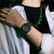 Casio G-Shock Armbanduhr am Handgelenk mit schwarzem Zifferblatt und grünen Akzenten.