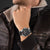 Armbanduhr am Handgelenk mit schwarzem Zifferblatt und schwarzem Armband