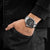 Herren-Armbanduhr am Handgelenk mit schwarzem Band und dunklem Zifferblatt