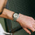 Herren-Armbanduhr am Handgelenk mit silbernem Metallarmband und beigem Zifferblatt