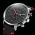 Gros plan d'une montre pour homme : cadran noir, boîtier argenté et lunette noire, aiguille rouge