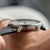 Montre pour homme en gros plan au poignet, bracelet en cuir noir et couronne
