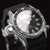 Montre homme en détail : cadran noir avec index verts et lunette de plongée