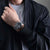Montre pour homme portée au poignet avec cadran noir et bracelet en acier inoxydable