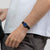 Damenuhr am Handgelenk mit blauem Zifferblatt und schwarzem Armband, weißes Shirt