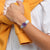 Damenuhr am Handgelenk mit lila Zifferblatt, transparentem Gehäuse und hellblauem Silikonarmband