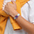 Damenuhr am Handgelenk mit lila Zifferblatt, transparentem Gehäuse und hellblauem Silikonarmband