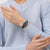 Armbanduhr am Handgelenk im Strickpullover: petrolfarbenes Band, violettes Zifferblatt