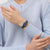 Armbanduhr am Handgelenk: petrolfarbenes Band, rundes Zifferblatt mit violettem Design