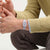 Damenuhr am Handgelenk mit lilafarbenem Kunststoffarmband und analogen Zeigern