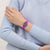 Damenarmbanduhr am Handgelenk mit lila, texturiertem Armband