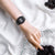 Montre pour femme avec écran numérique noir et bracelet noir au poignet, vue de côté