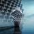 Casio G-SHOCK MR-G Herrenuhr mit dunklem Metallarmband und blauem Zifferblatt, seitliche Ansicht