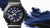 Casio MR-G Herrenuhr, schräger Blick: blaues Zifferblatt, schwarzes Gehäuse, Kautschukband.